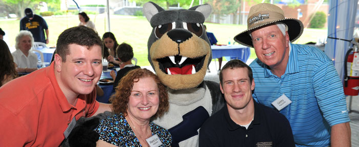 Parents and students smiling with mascot