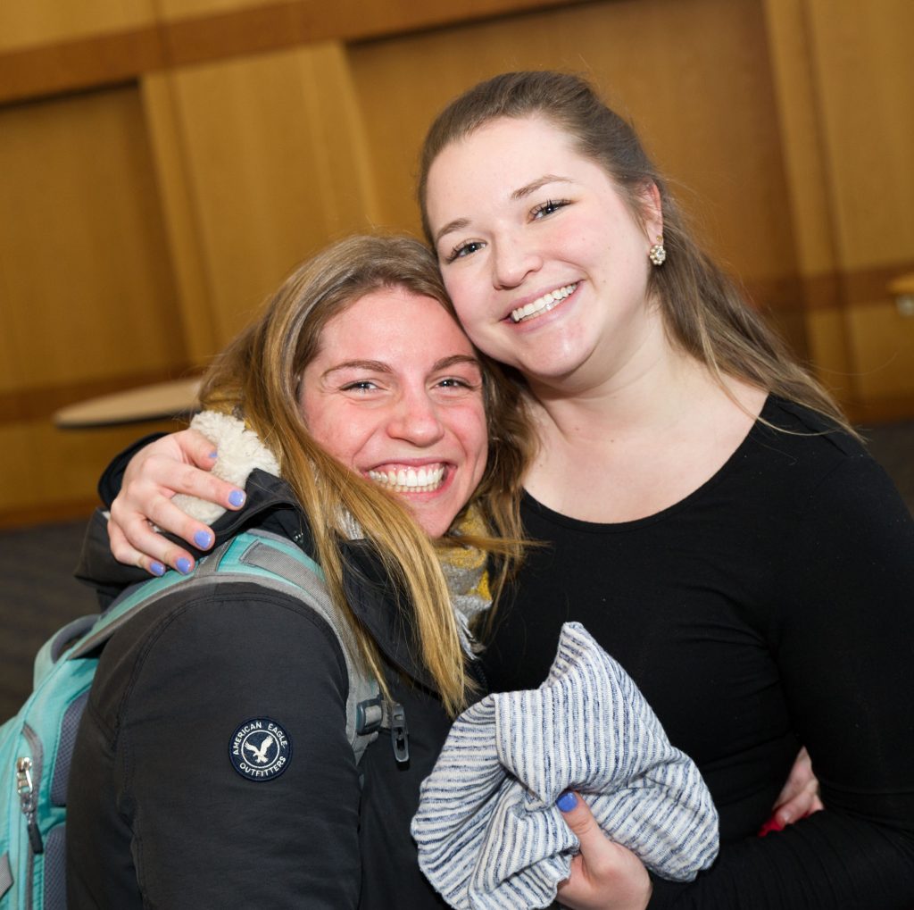 Two women hugging and smiling at the camera