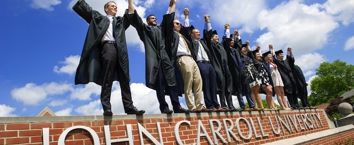 Triumphant grads on the John Carroll sign